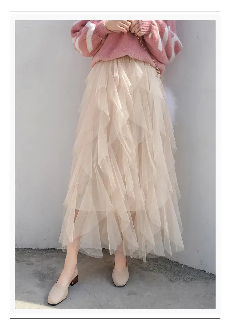 A flowing beige multi-layered tulle skirt with soft airy texture and gentle ruffles featuring easy matching mesh stitching for versatile wear.