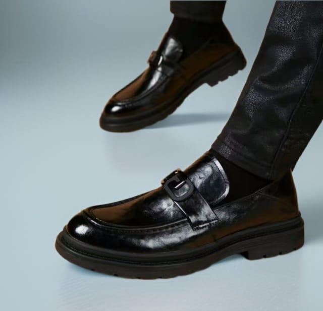Black glossy business casual leather loafer featuring black patent leather, a single buckle strap, and a chunky rubber sole ideal for business casual wear.