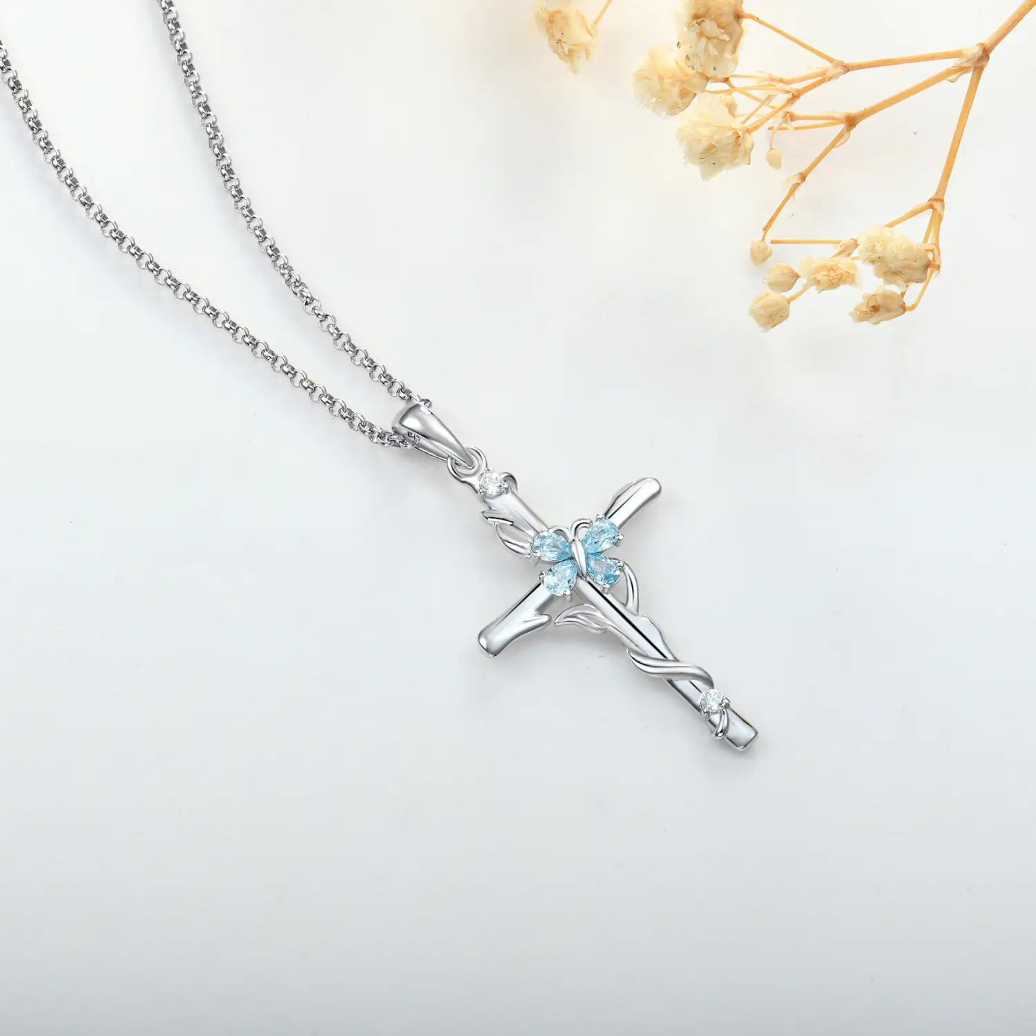 Silver cross necklace sterling featuring a delicate chain and an ornate pendant with light blue gemstones in sterling silver for women.