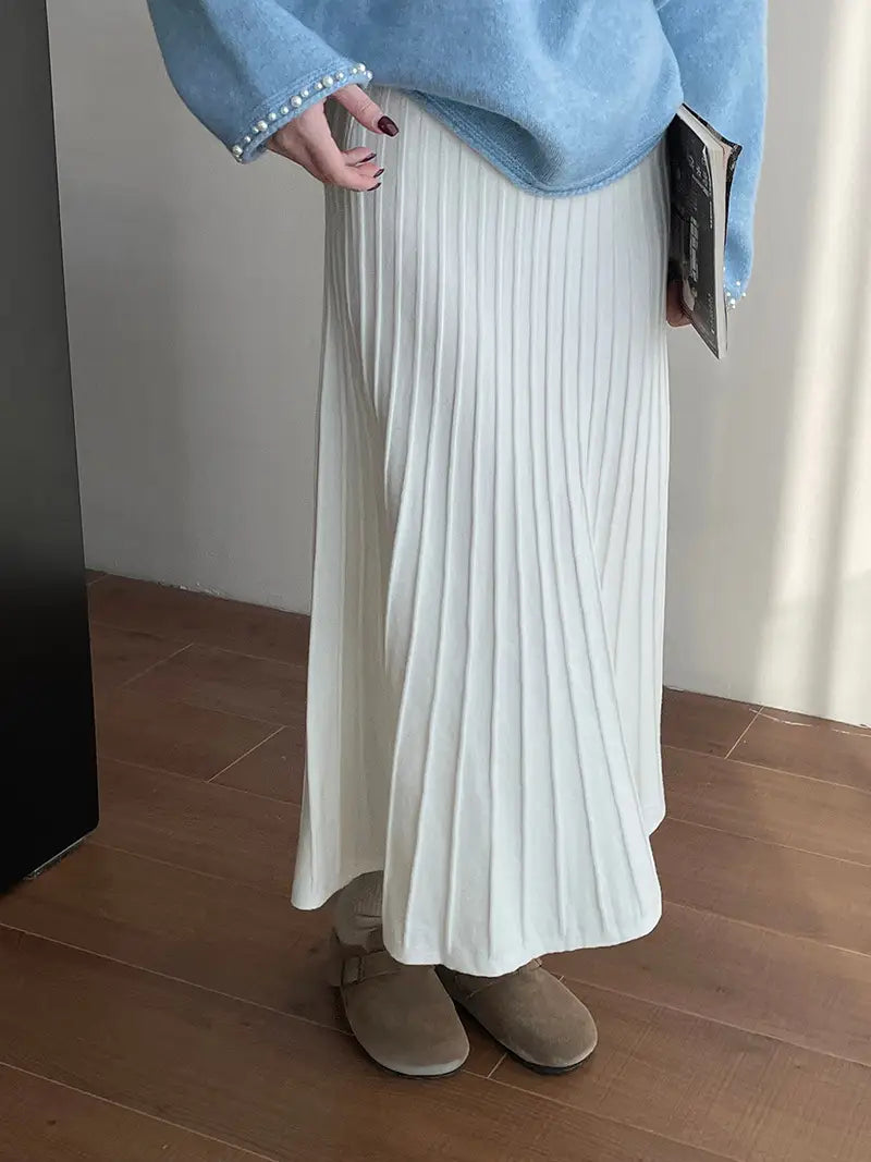 a flowing white pleated midi skirt made of soft textured fabric featuring a korean elastic waist and knitted pleated design