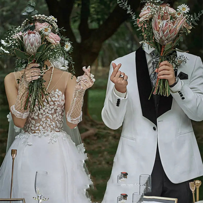 white lace gloves with delicate beaded detailing and sheer mesh fabric for wedding dress in a summer couple photo shoot