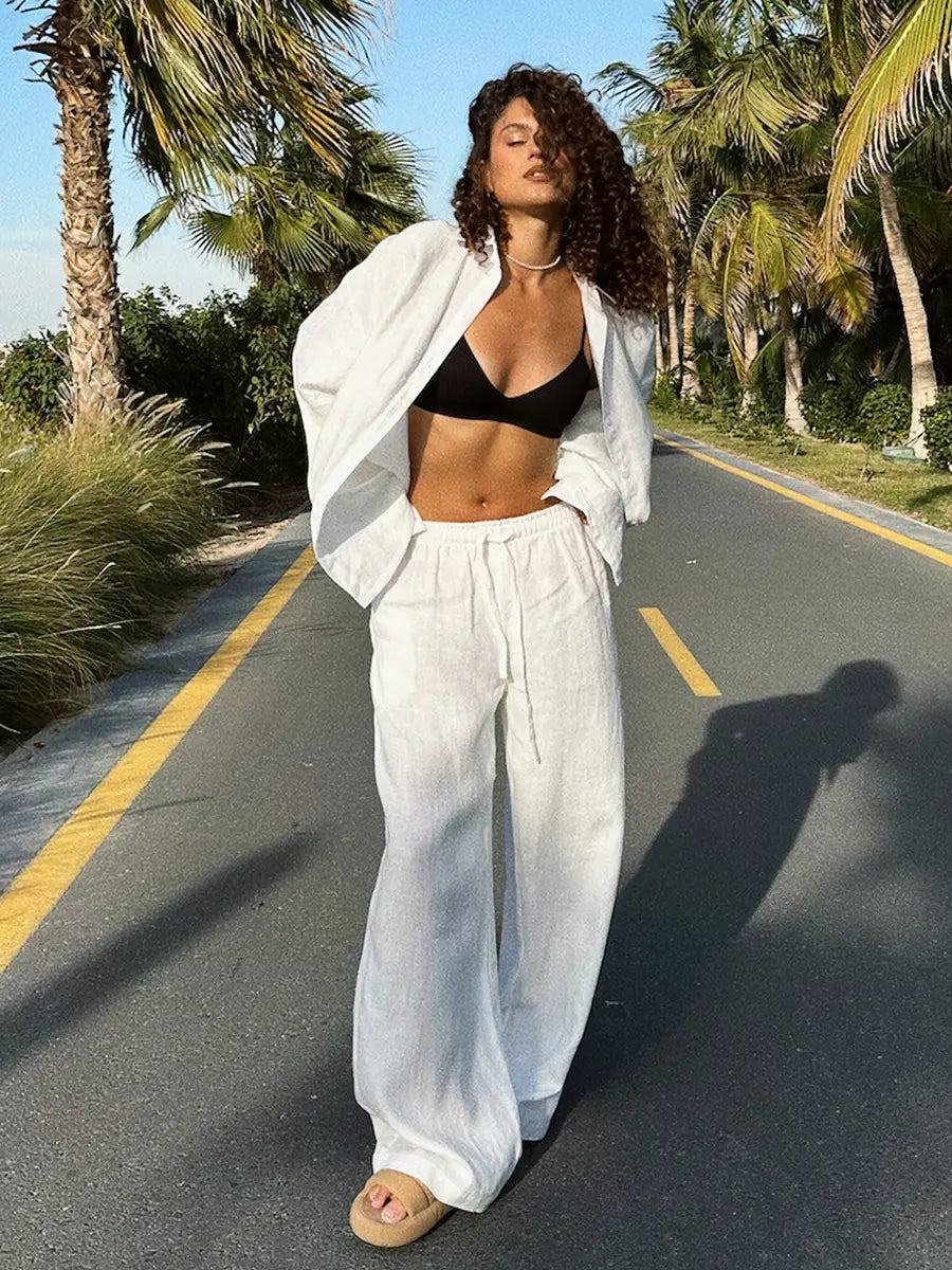 white linen wide-leg pants with a drawstring waist paired with a long sleeve cotton shirt trousers suit in white for a polished outfit.