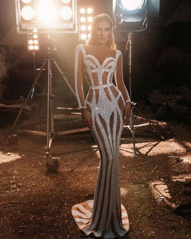 A shimmering silver sequined evening dress with a fitted silhouette and dramatic cutouts designed for a sprinkled gold banquet or gold banquet dress occasion.