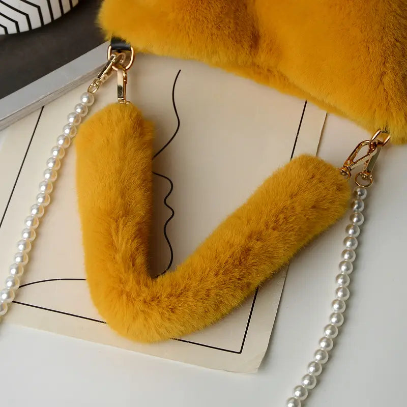 yellow checkerboard plush bucket bag featuring a vibrant yellow faux fur crossbody strap with gold-toned hardware and a pearl chain design