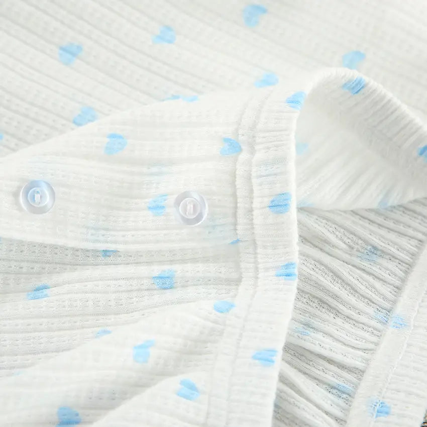 white cotton muslin baby onesie featuring light blue knitted heart printing with clear snap buttons for a heart printing comfortable fit in the knitted heart printing ribbed loungewear set
