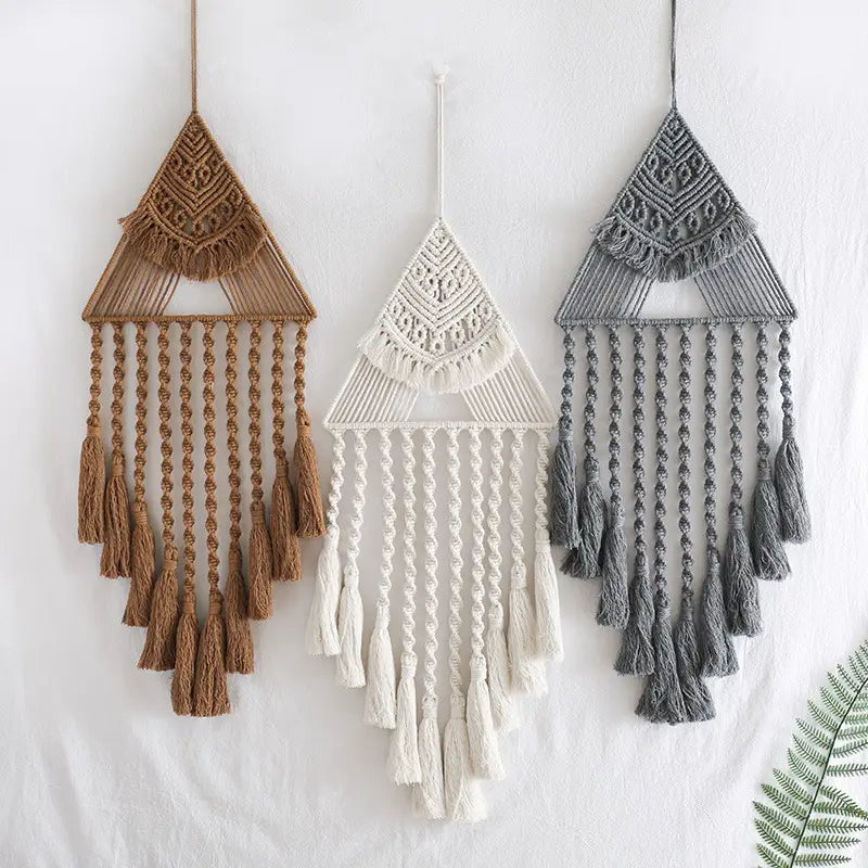 Three handwoven home decor triangle dream catchers in earthy tan, cream, and gray tones feature intricate woven patterns and dangling tassels for wall decoration.