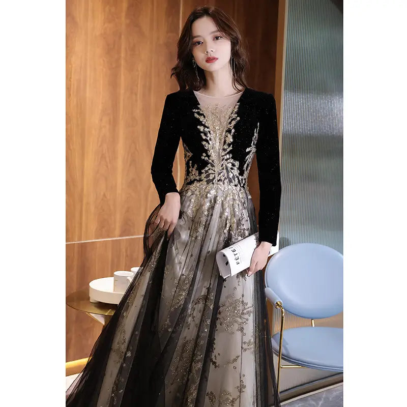 Elegant black moderator long velvet gown with long sleeve annual party design featuring intricate gold beading and sheer overlay.