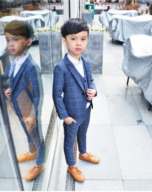 blue plaid children’s three-piece fashion suit with a white shirt and tan leather shoes designed as a stylish comfort suit for formal occasions.