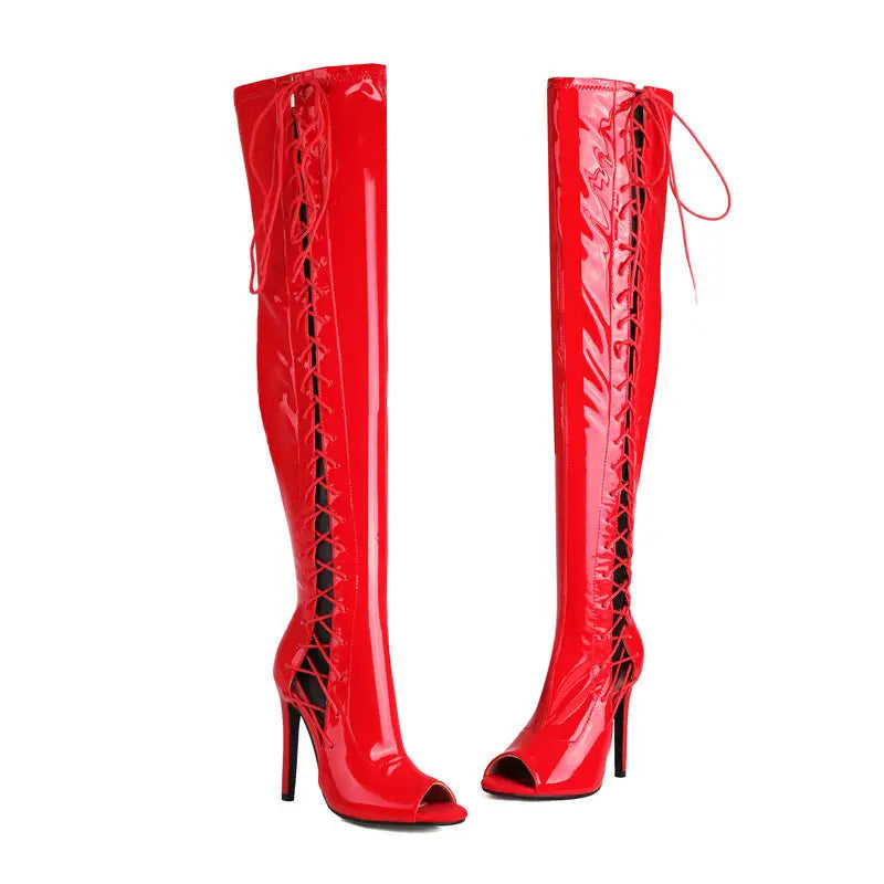 Shiny red patent leather female over the knee boots with lace-up sides, peep-toe design, and moderate heel height.
