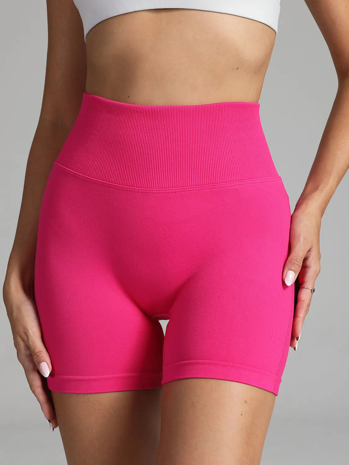 Bright pink solid color seamless yoga shorts women with a ribbed waistband in high waist design.