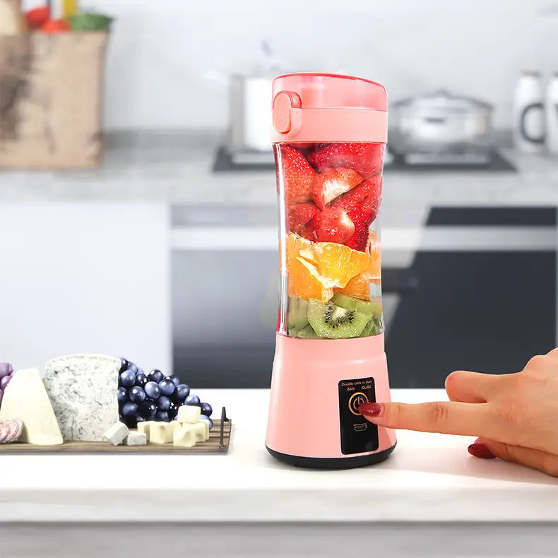 pink portable electric fruit juicer filled with sliced strawberries oranges and kiwi designed as a USB rechargeable mixer