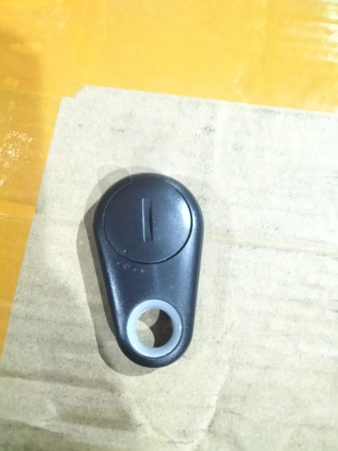 black plastic water drop anti lost object finder with circular top button and attachment hole for use as lost object finder