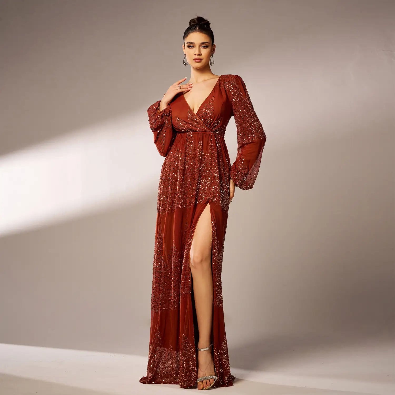 A shimmering rust-colored sexy long sequined evening dress featuring long sheer bell sleeves and a high slit.