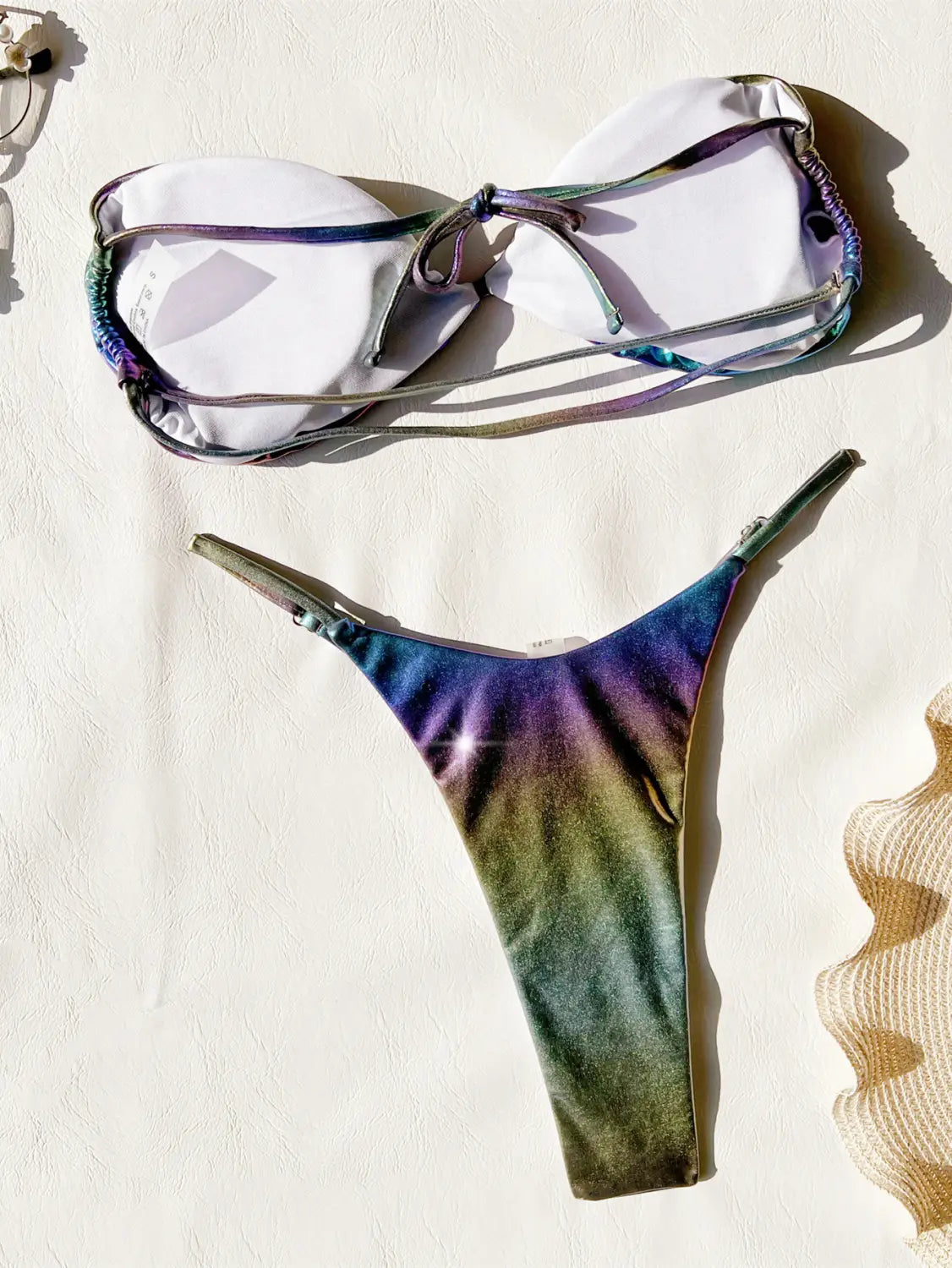 A shimmering iridescent bikini gradient swimsuit featuring a gradient of purple, blue, and green hues on the fabric.