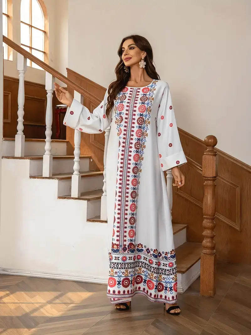 A flowing white long sleeve maxi dress featuring intricate red, blue, and pink floral print embroidery and rhinestone bead embellishments along the neckline, sleeves, and hem.