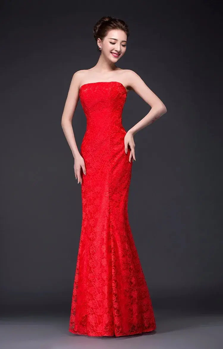A vibrant red fuchsia strapless wedding dress featuring a long mermaid-style silhouette with intricate lace detailing.