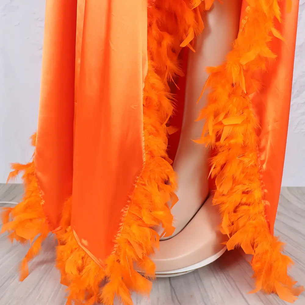 Vibrant orange feather boa draped over a mannequin showcasing a loose dress luxury fully surrounded by feathers for an opulent look.
