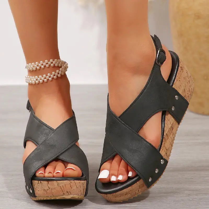 black fish mouth rivet wedges snadals with cross straps, cork sole, silver studs, and beige suede material