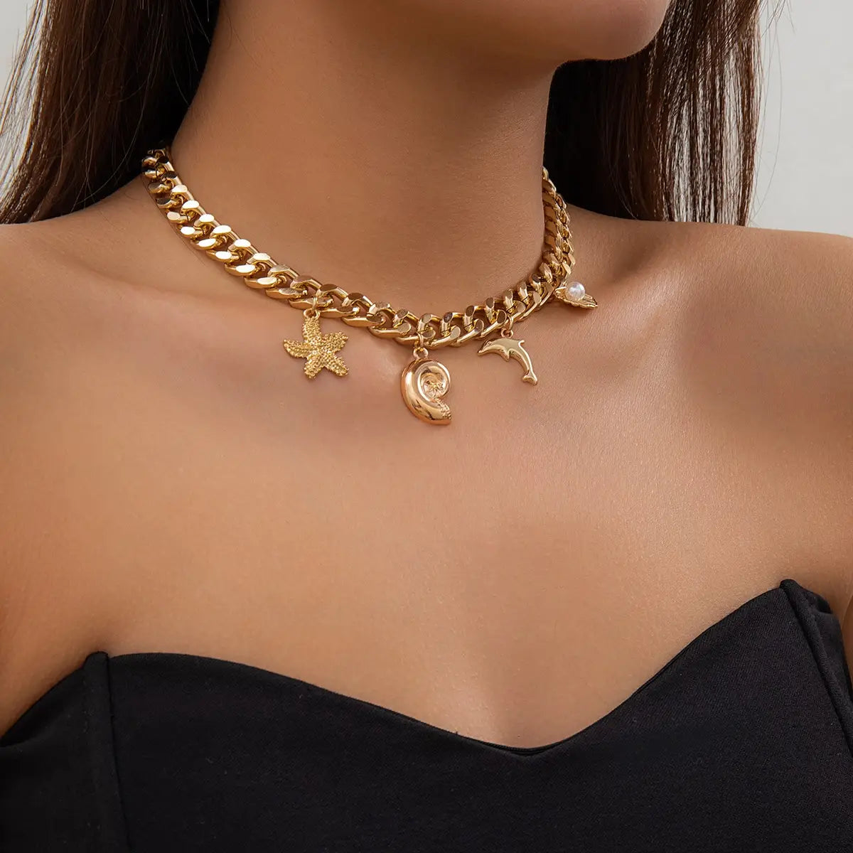 gold-toned chunky chain choker necklace and bracelet set featuring conch dolphin starfish and seashell charms in a boho style.