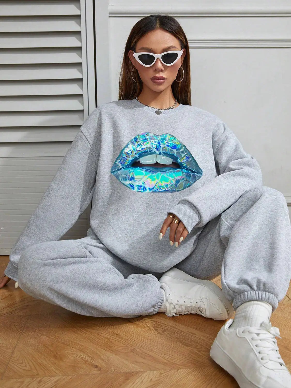 women’s gray crew neck long sleeve sweatshirt featuring a large iridescent blue and teal lips graphic printed on the front
