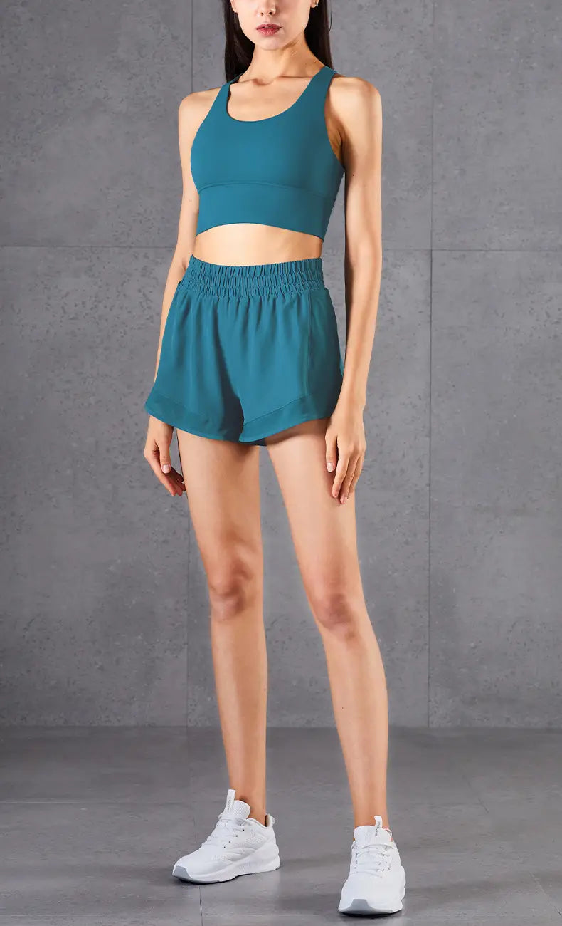 teal two-piece athletic set with mesh pockets fitness design featuring a cropped tank top and high-waisted breathable fitness pants with elastic waistband