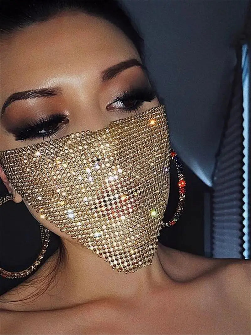 A shimmering gold flash jewelry mask adorned with a dense, sparkling array of rhinestones showcasing explosive metal flash design.