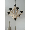 A rustic light wood chandelier with six candle-style lights and distressed white wood for dining hall entrance