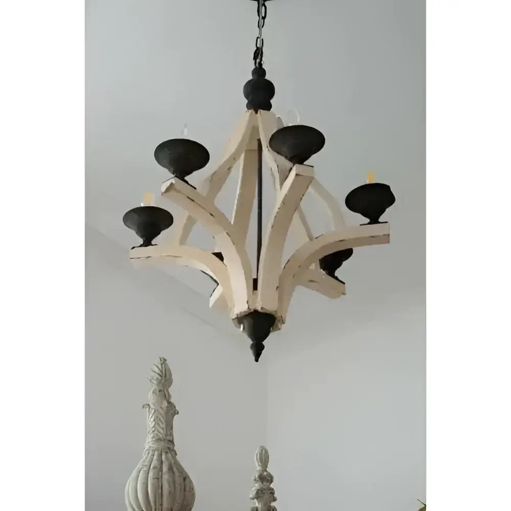 A rustic light wood chandelier with six candle-style lights and distressed white wood for dining hall entrance