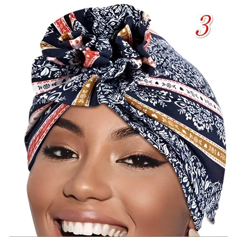 A navy blue patterned vibrant printed headband with white floral and gold trim tied in a decorative knot at the top