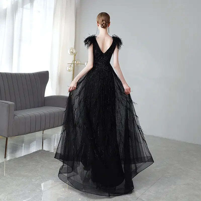 Elegant black double shoulder evening dress featuring a beaded bodice with sequins and feathered shoulder accents.