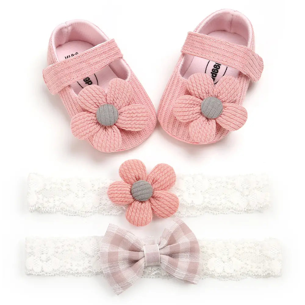 white flower princess baby shoes in pink knitted fabric with textured flower design and gray fabric centers for baby and toddler use