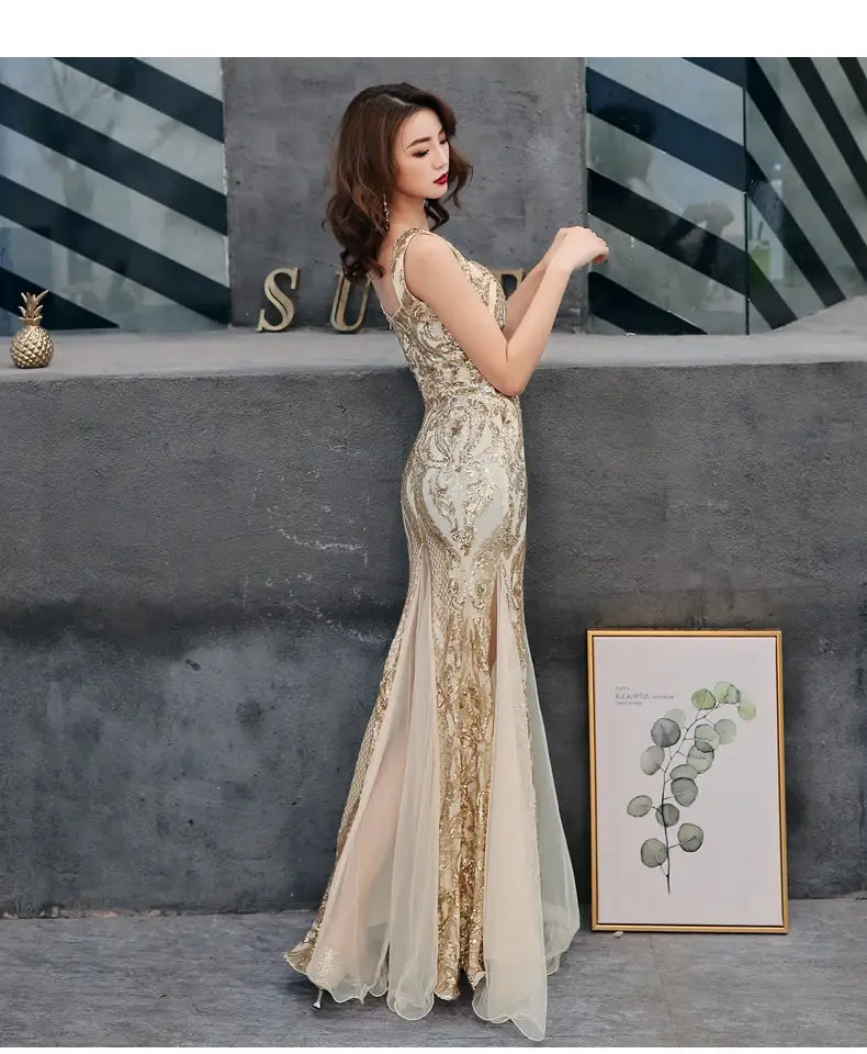 Black fishtail long summer sequins sling evening dress in shimmering gold and cream with intricate beading and embroidery featuring a fitted bodice and flowing mermaid-style skirt.