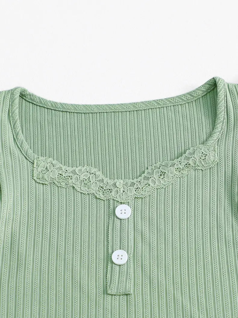 a soft mint green ribbed knit top with delicate lace trim along the neckline and white buttons down the front, complementing a black ribbed lace ruffle sleeve pajama set.