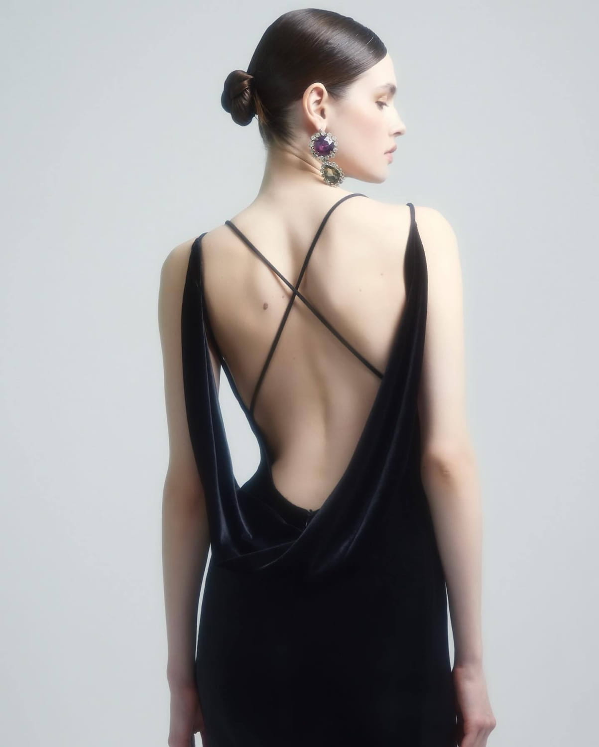 black camisole backless slim fit velvet floral gown shown from the back with deep cutout and crisscross straps