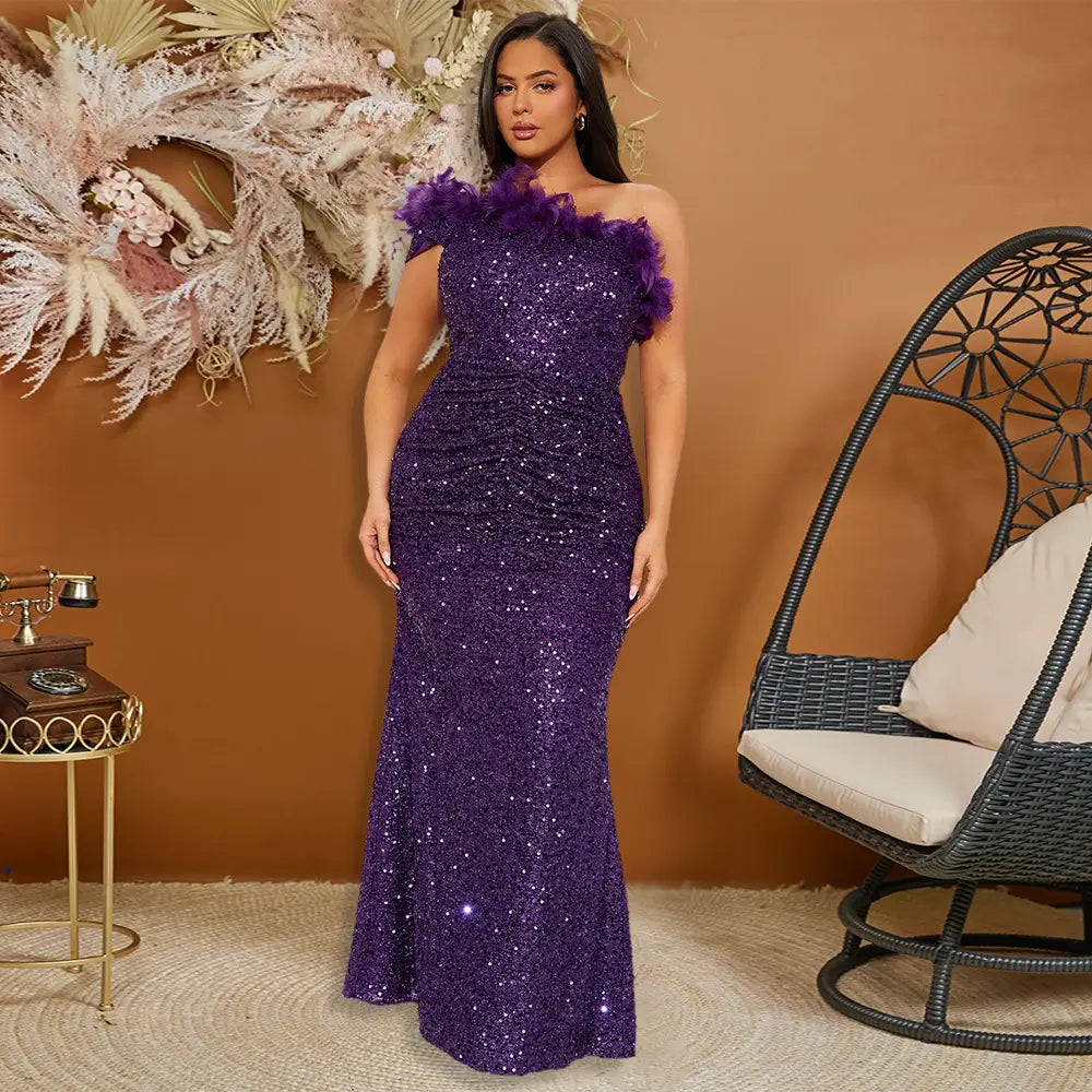 A shimmering purple mermaid-style evening gown featuring a ruched bodice and black paillette feather stitching with feather stitching sequin details on the shoulders.