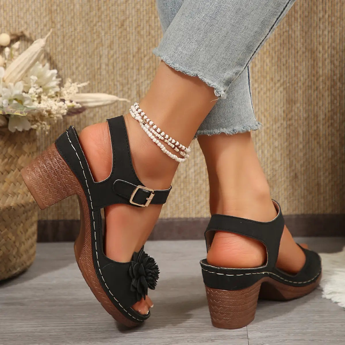 black suede wedge heel sandals with a textured wooden chunky heel and a decorative black fabric flower on the toe perfect for summer flowers chunky heel sandals.