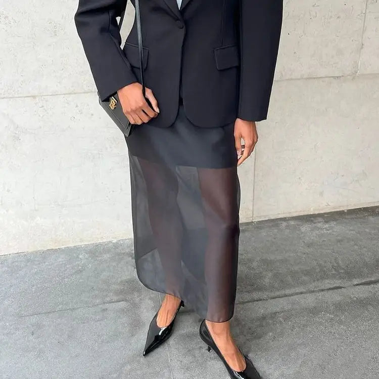black sheer high waist slit sheath skirt paired with a solid black blazer overlay showcasing the elegance of a waist slit sheath style midi skirt.