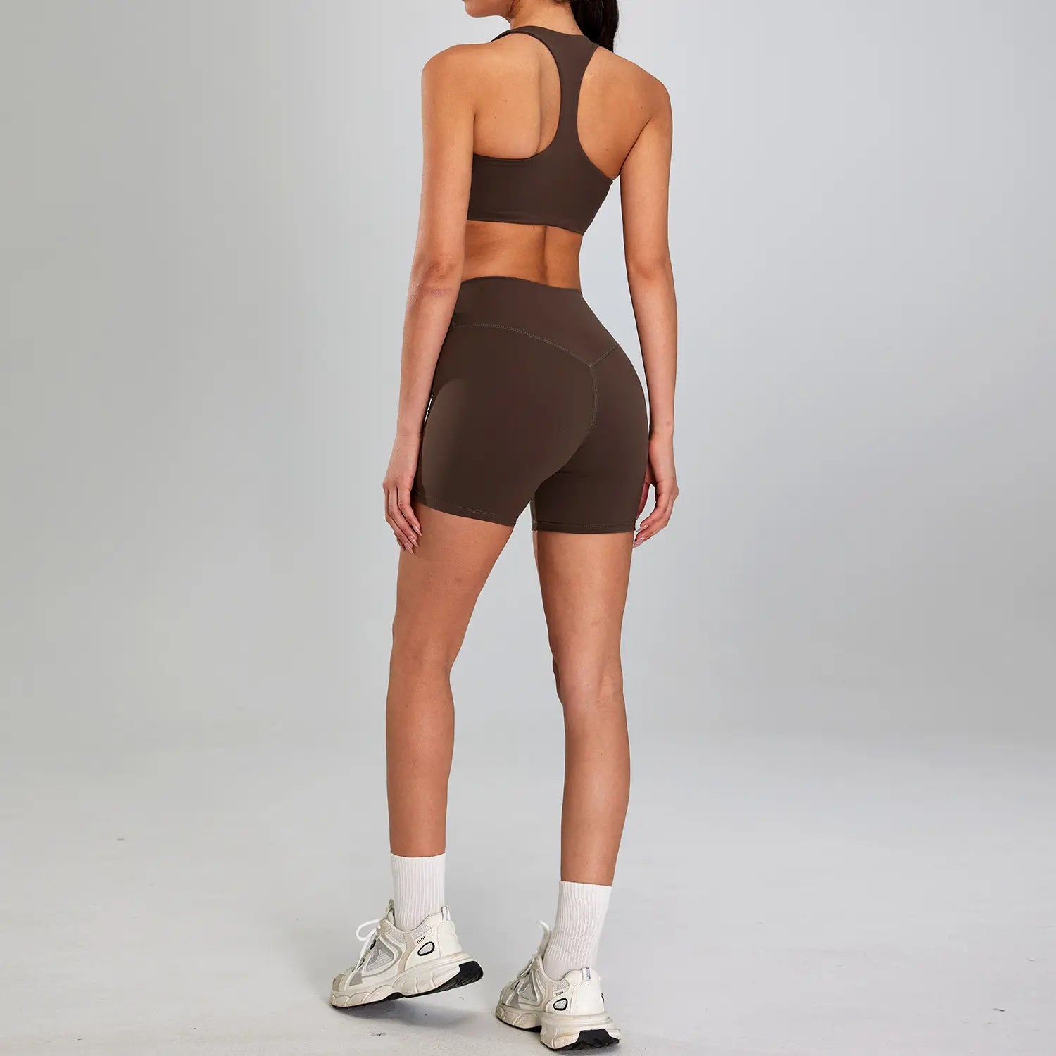 brown seamless athletic two-piece sports suit outdoor with racerback top and high-waisted shorts designed for outdoor running nude use