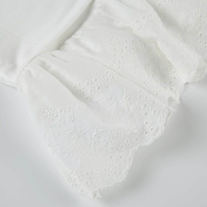 a delicate white lace handkerchief with intricate eyelet patterns and a softly frayed edge complementing french high waist elastic double layer lace pantskirt design.