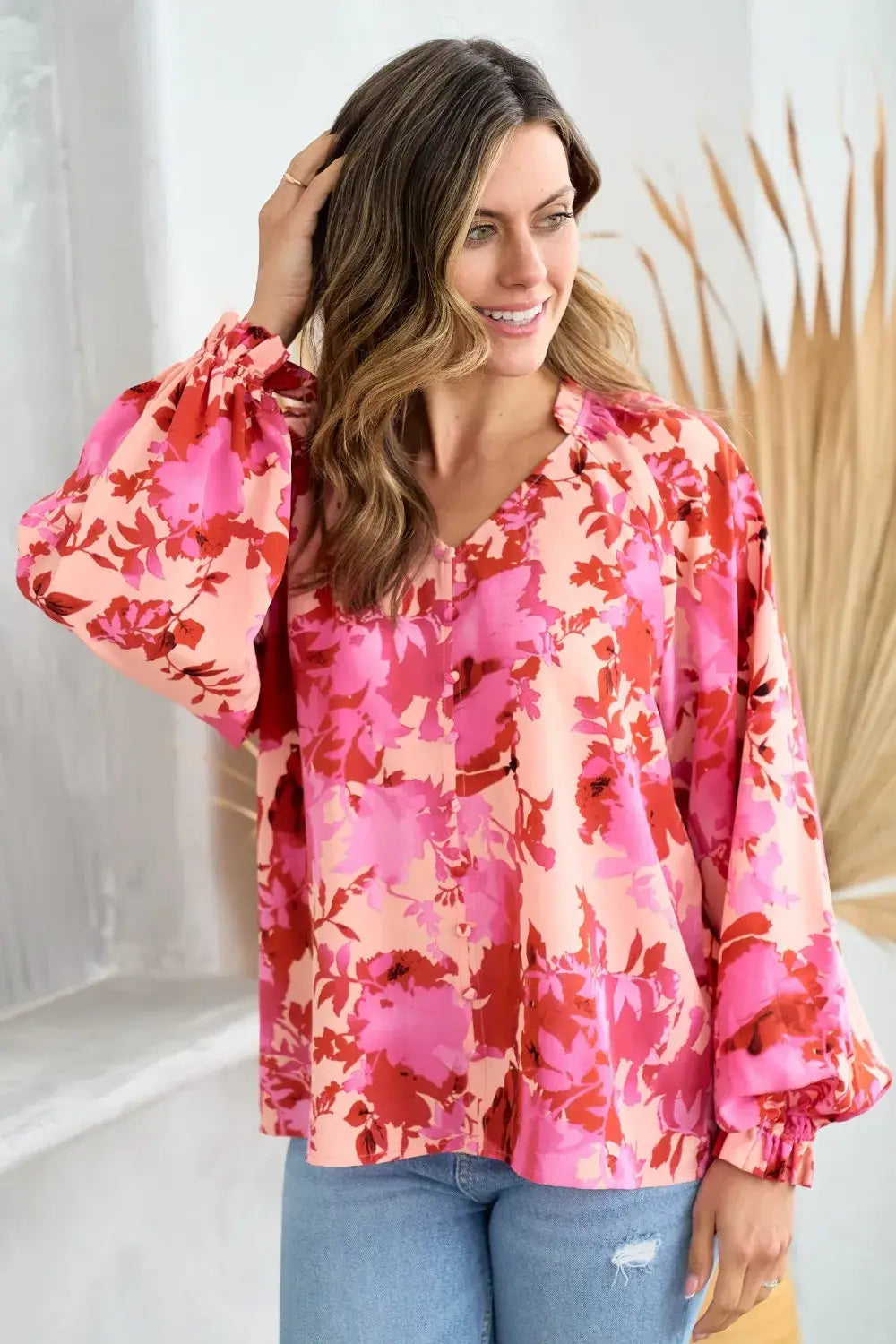 A vibrant pink and red decor button floral blouse featuring puffed sleeves and a v-neckline perfect for stylish wear.