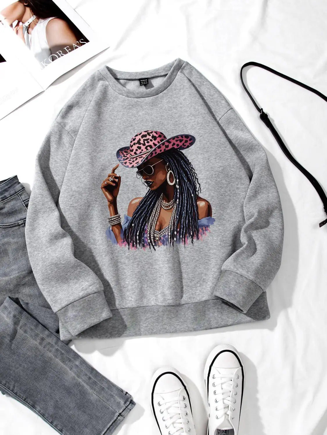 gray long sleeve sweatshirt featuring a vibrant graphic of a woman wearing a leopard-print hat and sunglasses
