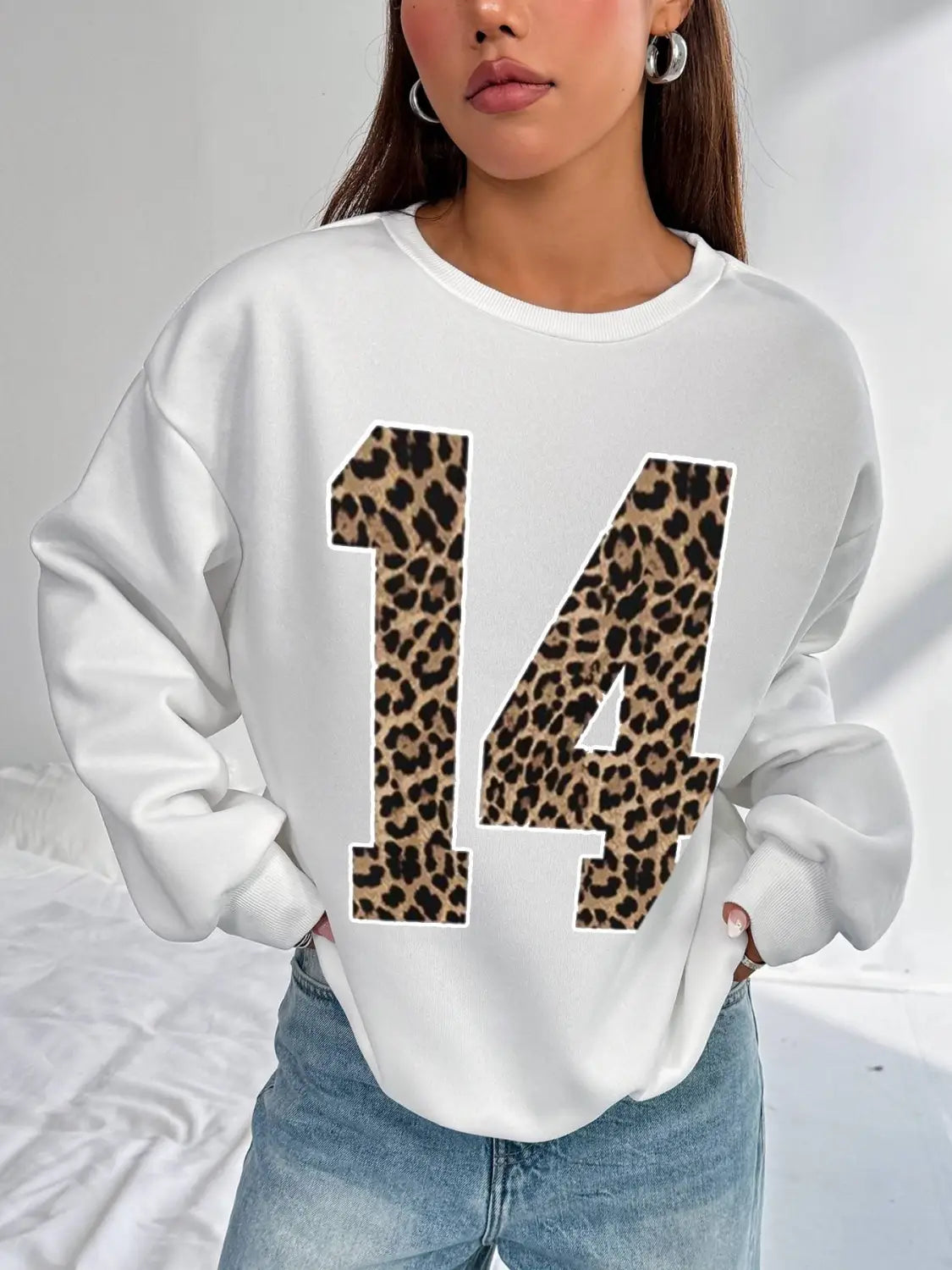 White crew neck sweatshirt featuring bold black leopard print numbers 14 on the front
