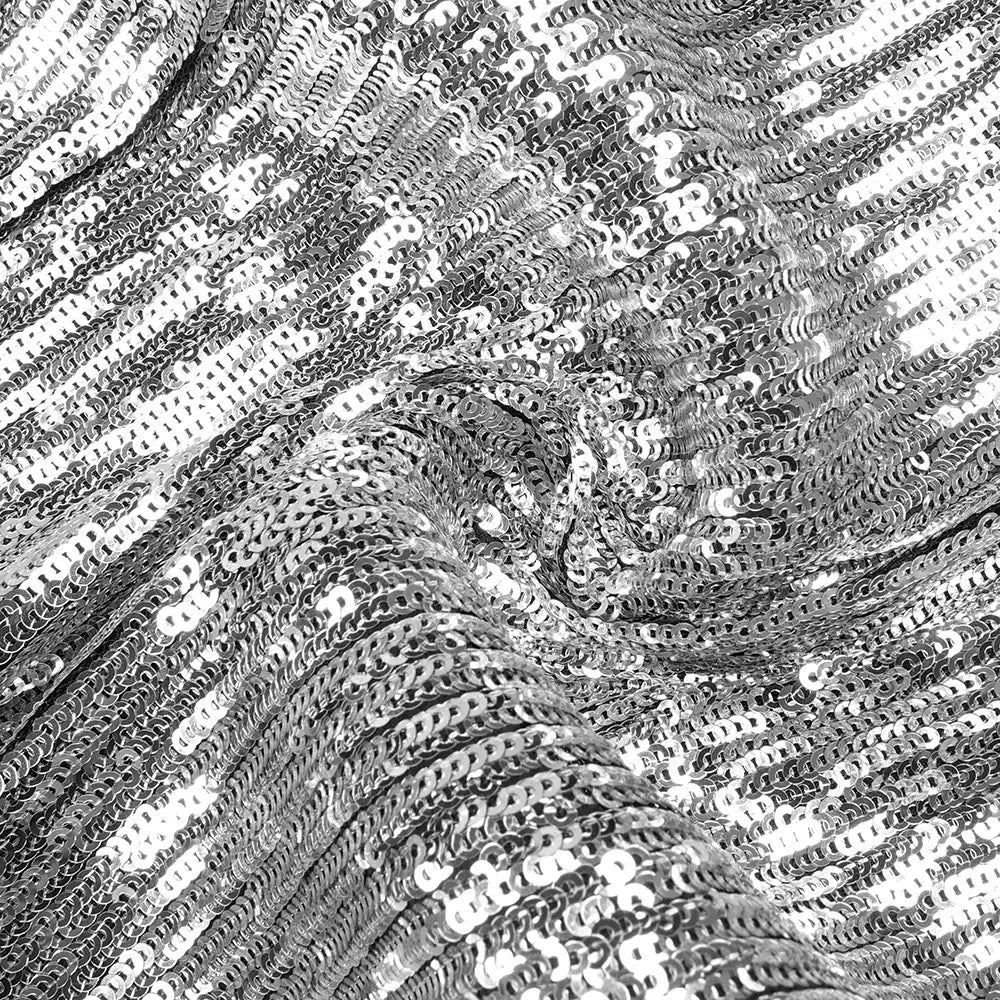 Shiny silver sequined fabric of a silver strapless sequin skirt set with a shimmering reflective surface.