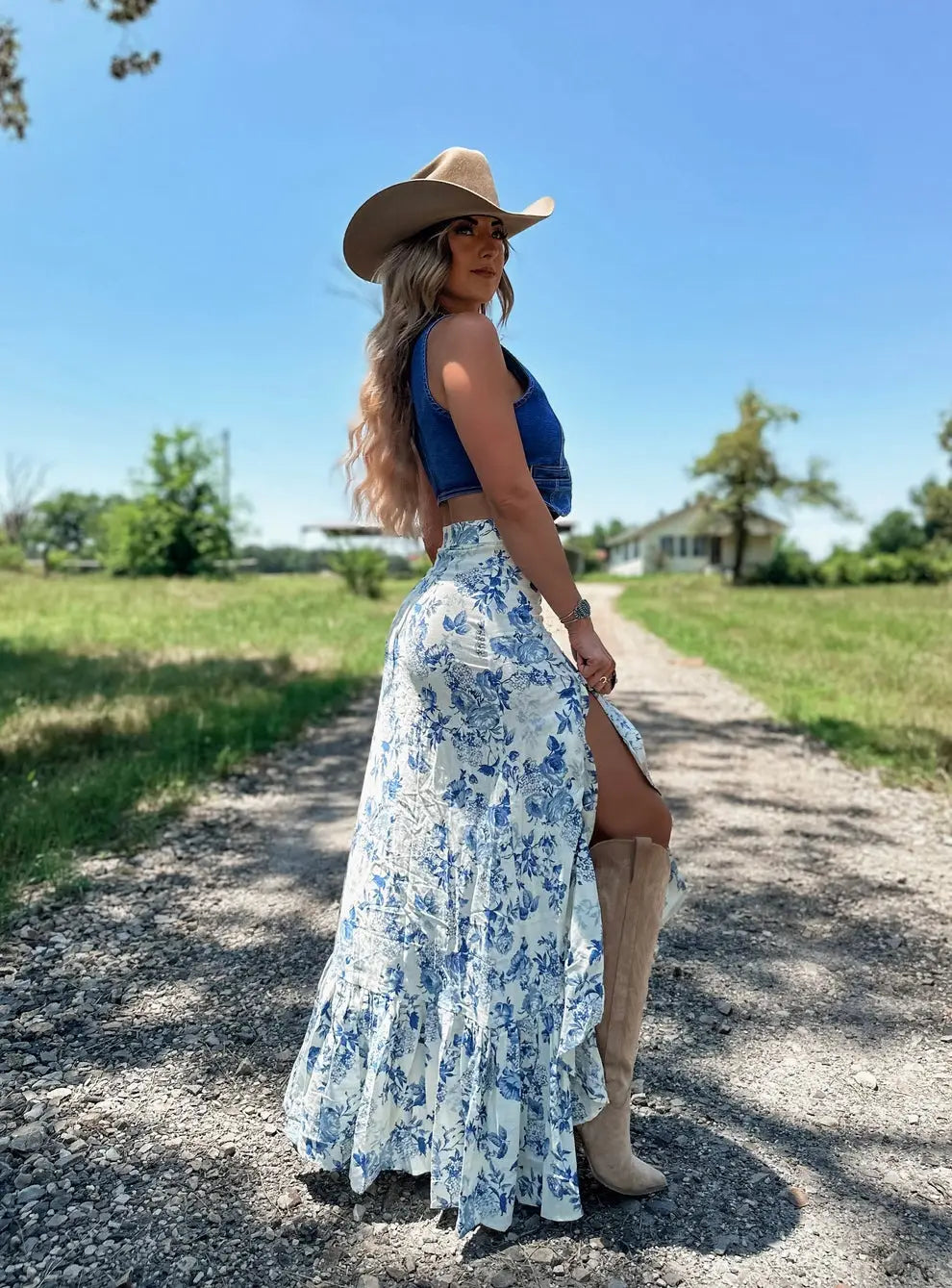 a flowing white maxi skirt with a delicate blue floral pattern featuring split print pleating and a pleating big hem with ruffled detail