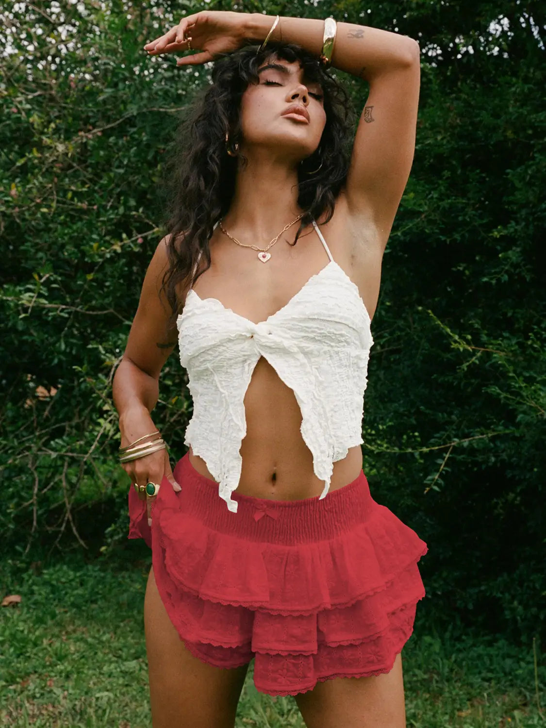 white lace halter top with a front bow and cutout detail paired with a white eyelet lace bow decorative bud skirt.