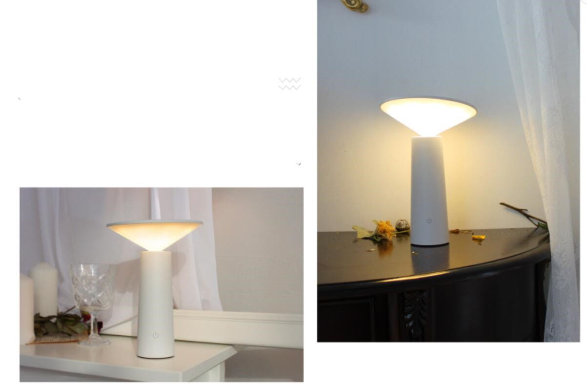 White cylindrical minimalist touch table lamp usb led with a smooth conical shade emitting a softly diffused warm glow ideal for led reading.