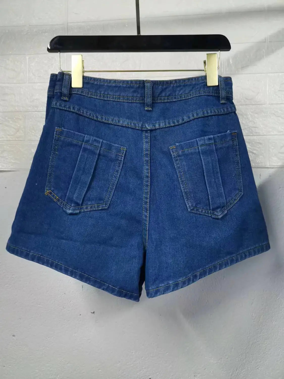 blue denim y2k street vintage asymmetrical skorts skirt showing the back side with classic pocket design and visible stitching