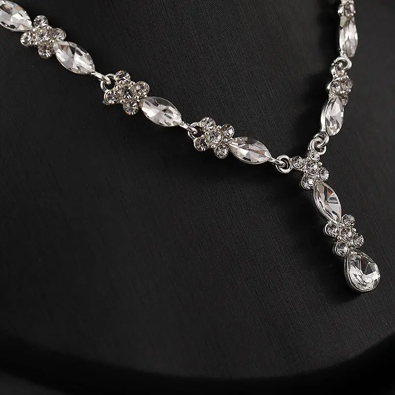 A luxury silver zircon necklace and earrings set featuring clear marquise and teardrop crystals with floral clusters of smaller stones for elegant women’s fashion.