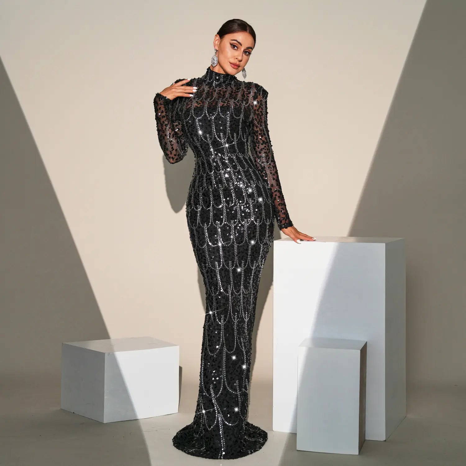 A black sequined banquet evening dress featuring long sleeve round neck design and intricate silver beadwork forming a cascading pattern.