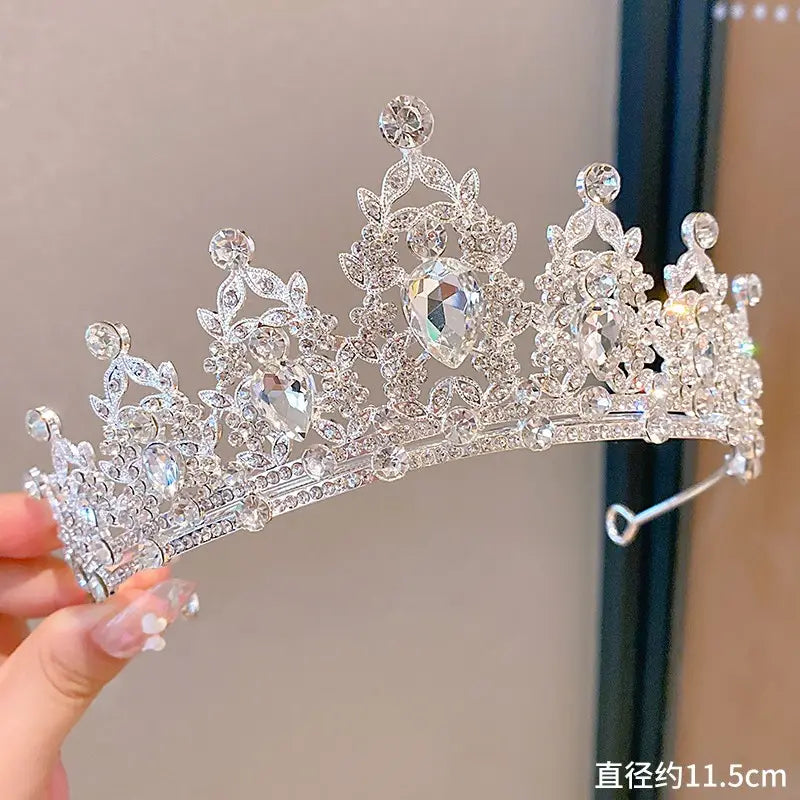 A sparkling silver crown headband from sweet fashion jewelry featuring intricate leaf and floral patterns with large pear-shaped crystals as elegant hair accessories.